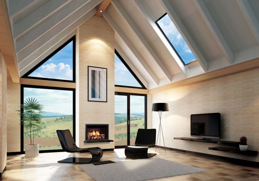 Open living space with vaulted ceilings, large windows, and a modern black chair set around a clean-lined fireplace with a scenic view outside.